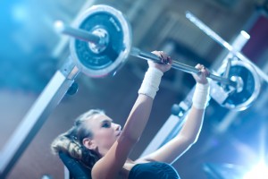 Young woman weight training. Focus on hand.